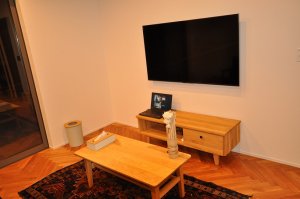 ヘリンボーンフロア、壁掛けテレビのあるリビング