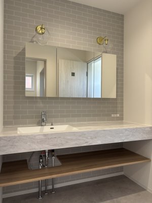 正面壁にレンガ調のアクセント。すっきりした造作洗面化粧台